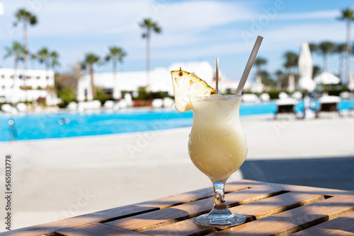 Pinacolada summer cocktail on the wooden table near the swimming pool, all inclusive resort photo