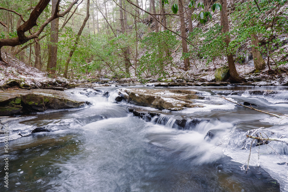 Obraz premium A clear mountain stream and water fall in winter with snow and ice. The Fiery Gizzard Trail on the Cumberland Plateau in Tracy City Tennessee USA.