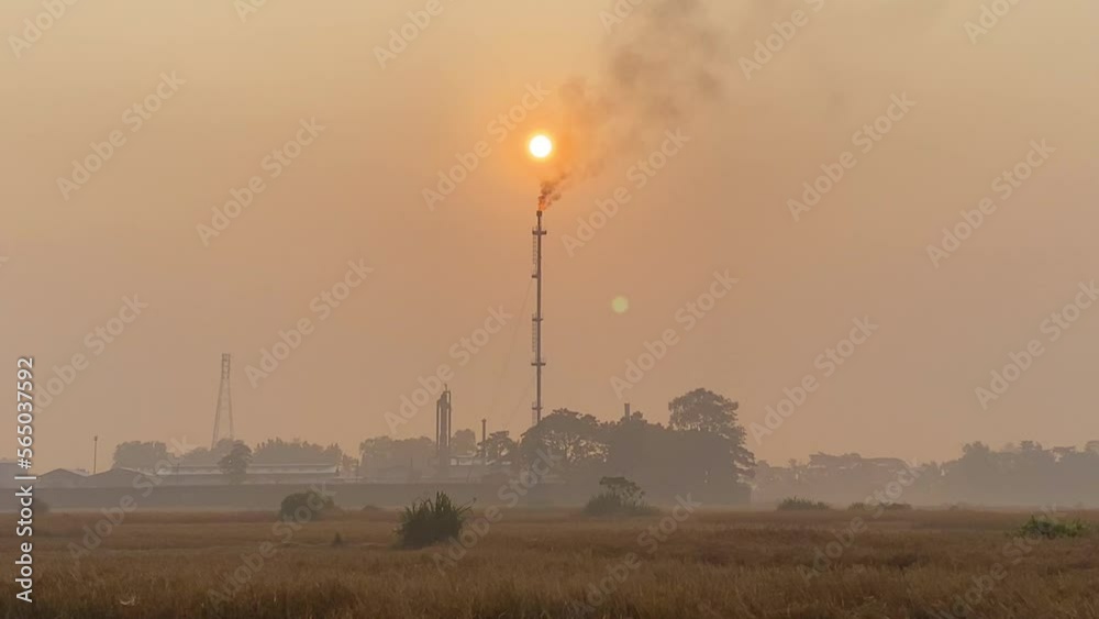 Establisher shot of Gas Plant with flame burning against hazy polluted sky Establisher shot of Gas Plant with flame burning against hazy polluted sky