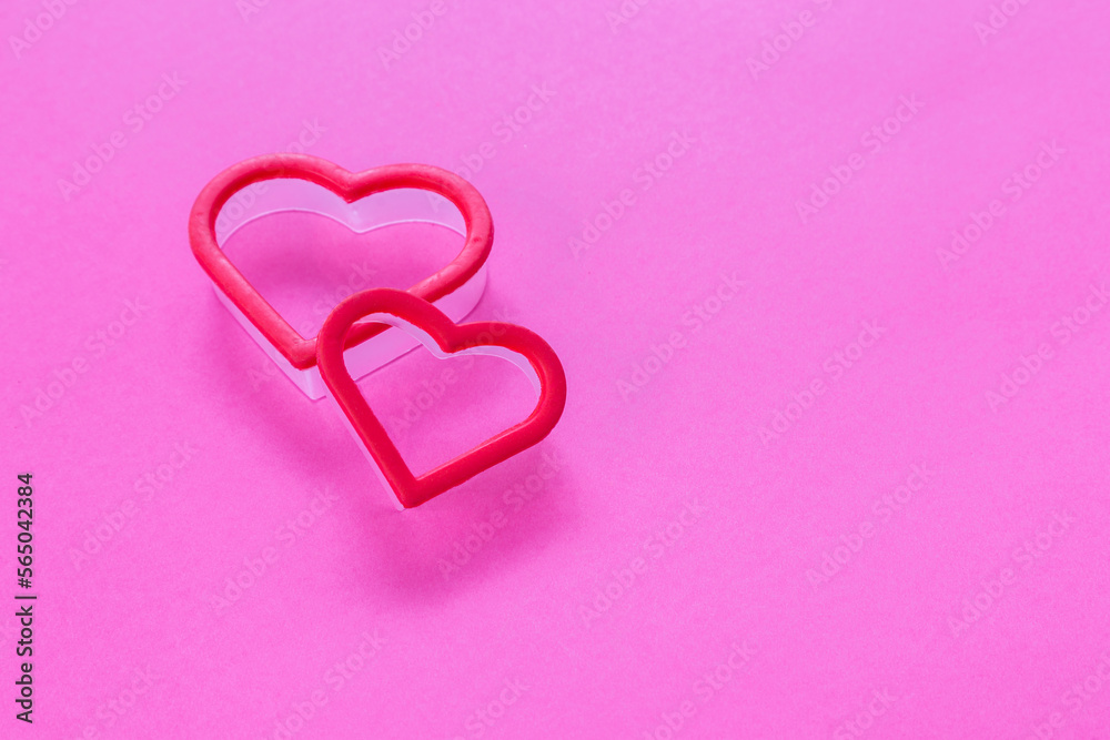 Two heart-shaped forms set on hot pink background with copy space