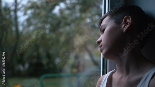 portrait of a sad boy looking out the window, loneliness, thinking about, moving camera, cinematic shot