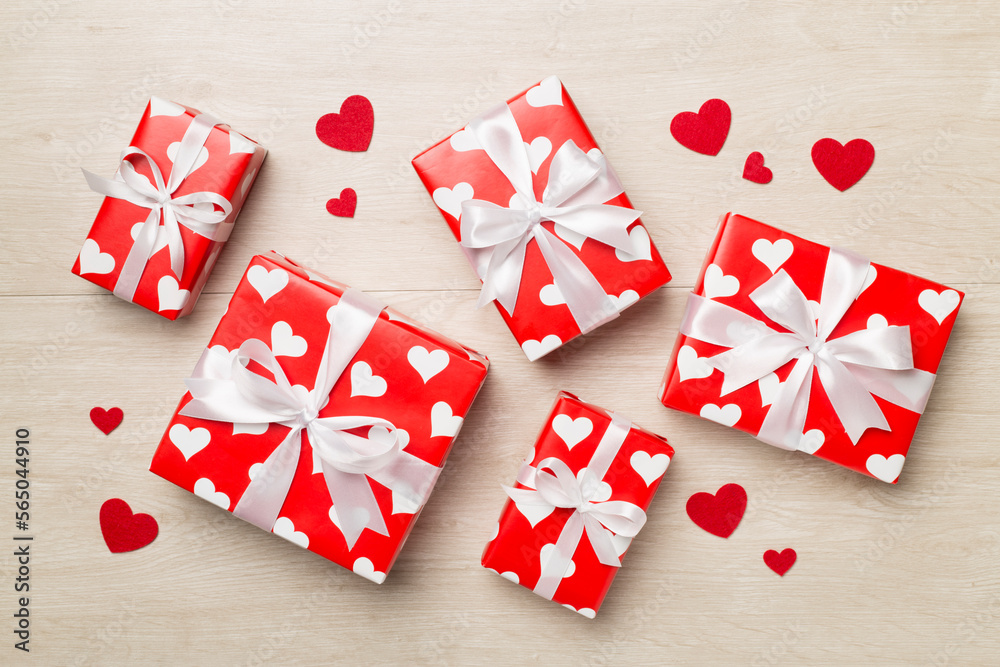 Gift boxes with hearts on wooden background, top view