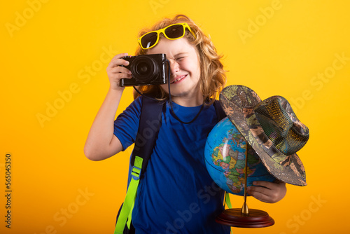 Travel and adventure concept. Little child boy tourist explorer with globe world. Discovery, exploring and education. Studio isolated portrait.