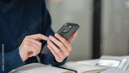 Close-up hand of a businesswoman using a smartphone at her office.