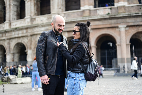 Happy Tourists couple traveling at Rome, Italy, poses in front of Altar of the Fatherland (Altare della Patria) and Piazza Venezia at, Rome, Italy