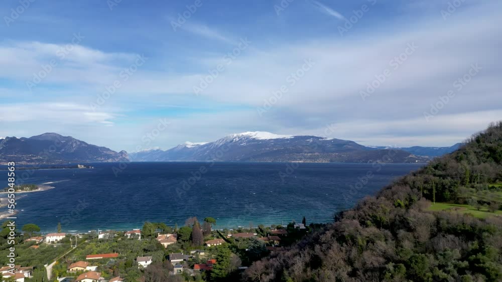 Drone aerial view lake garda italy summer sun. Flight near town of Manerba on south side of vacation destination shore region mountain panorama Drone aerial view lake garda italy summer sun. Flight near town of Manerba on south side of vacation destination shore region mountain panorama