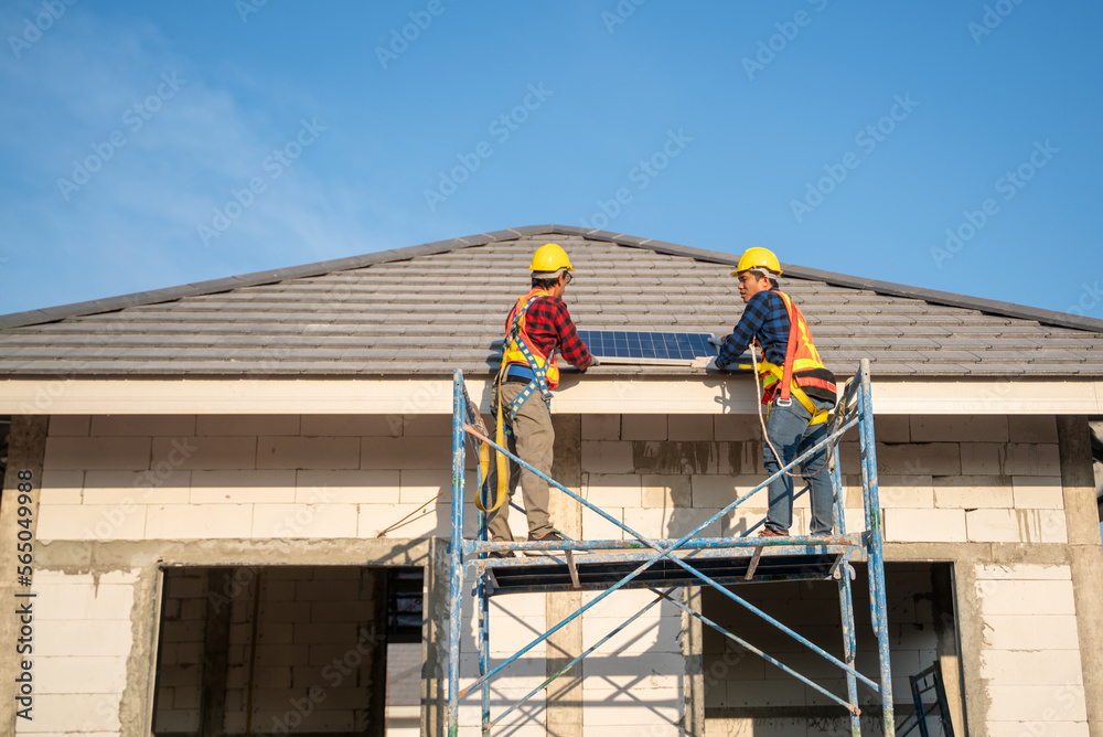 Team of two engineers installing solar panels on the roof