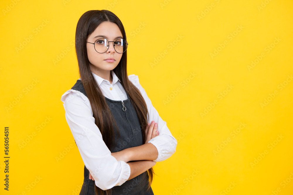 Cute serious little teenager girl crossing arms over yellow background. Copy space. Cute serious little teenager girl crossing arms over yellow background. Copy space.