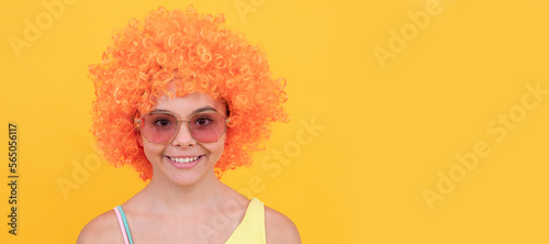 april fools day. happy childhood. birthday party. funny kid in curly clown wig. having fun. Funny teenager child in wig, party poster. Banner header, copy space.