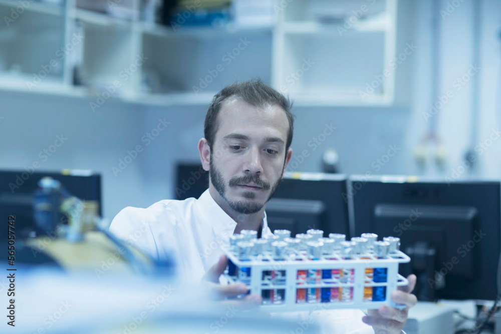 Young male scientist examining test tube in a laboratory, Freiburg Im Breisgau, Baden-Württemberg, Germany Young male scientist examining test tube in a laboratory, Freiburg Im Breisgau, Baden-Württemberg, Germany