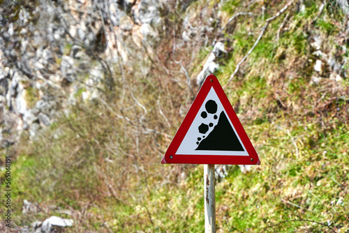 A sign warning of rock falls along a highway in the mountains