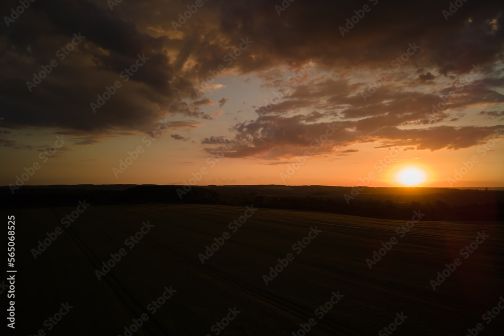 Aerial landscape view of yellow cultivated agricultural field with ripe wheat on vibrant summer evening