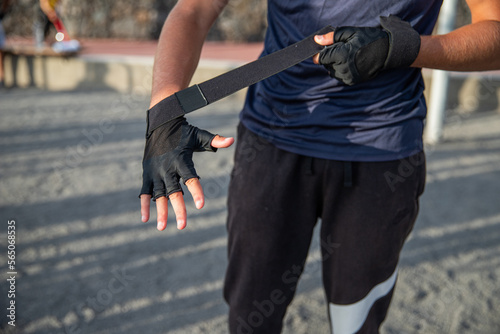 Close-up of an athlete's hand putting on protective gloves to train at the gym.