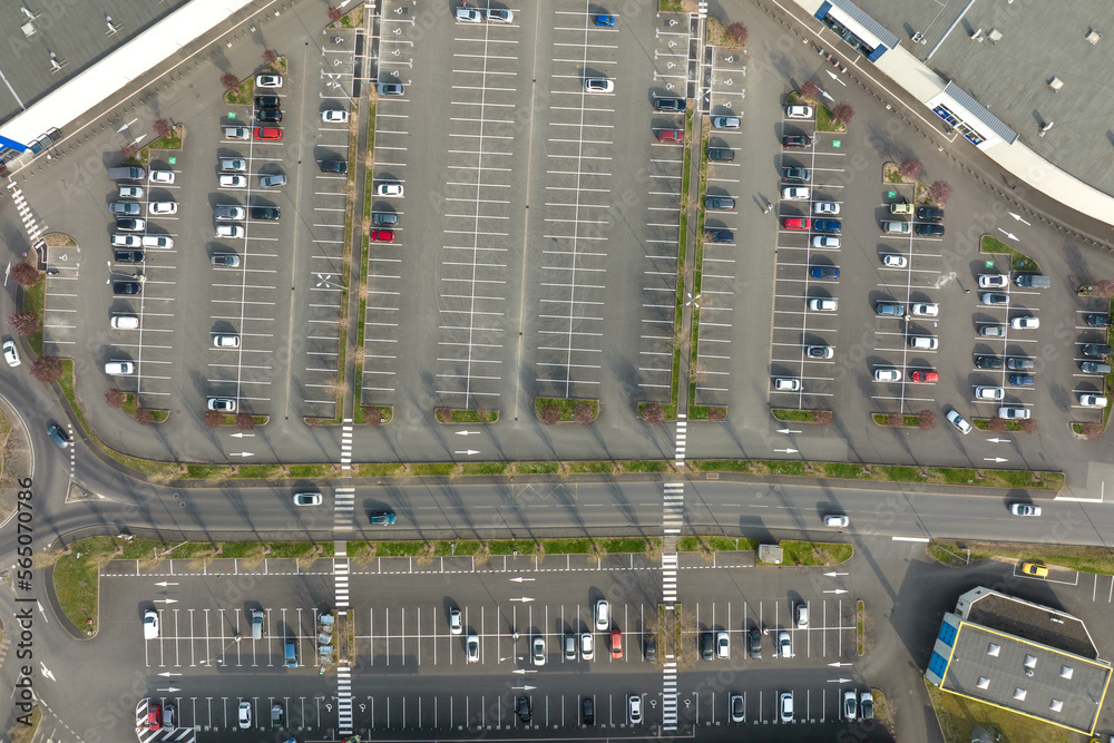 Aerial view of many colorful cars parked on parking lot with lines and markings for parking places and directions Aerial view of many colorful cars parked on parking lot with lines and markings for parking places and directions