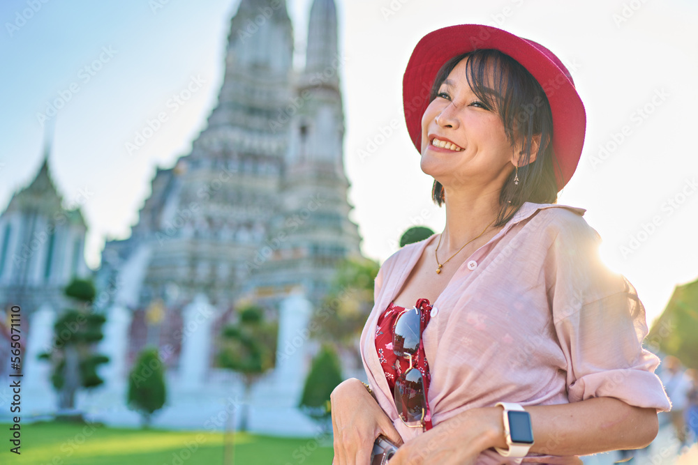 happy thai woman at war arun temple in background located in bangkok thailand