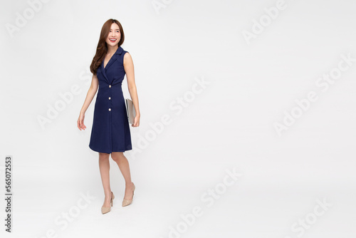 Happy young Asian business woman holding laptop computer and standing isolated on white background, Full body composition
