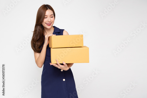 Asian woman holding package parcel box isolated on white background, Delivery courier and shipping service concept © comzeal