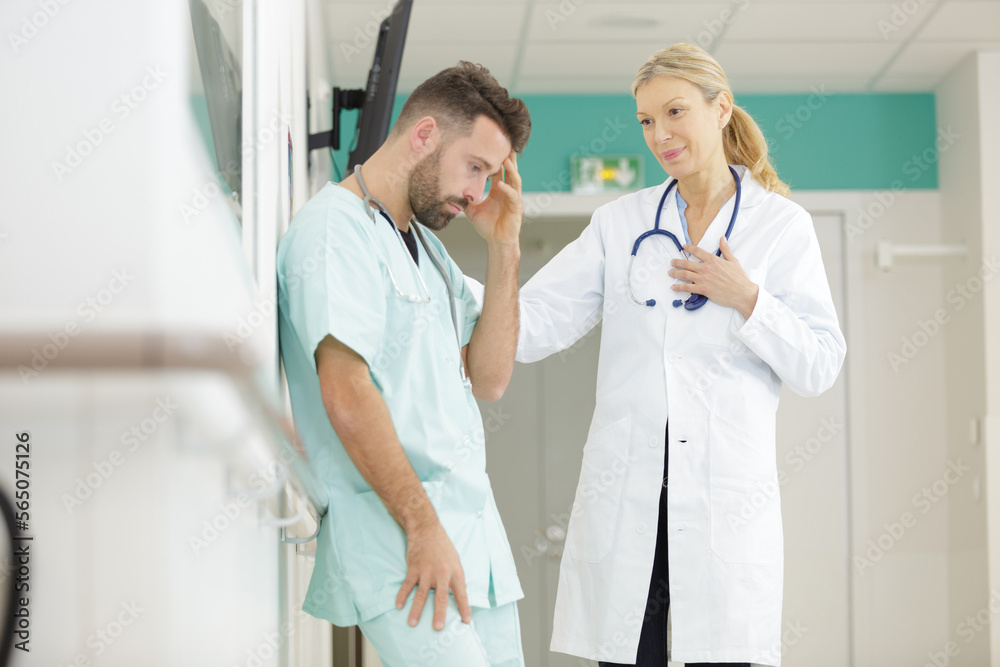 Obraz premium female doctor talking care of a worried male nurse