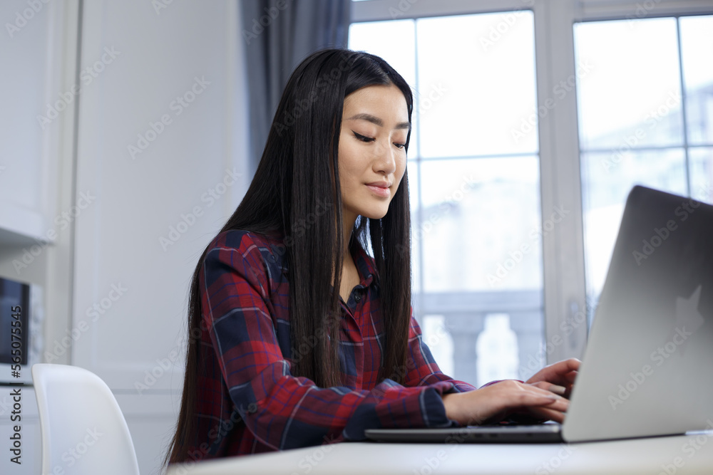 BIPOC programmer girl coding on modern laptop computer. Focused POC female works on notebook pc at home BIPOC programmer girl coding on modern laptop computer. Focused POC female works on notebook pc at home