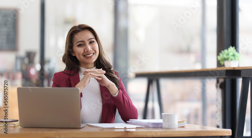 Attractive young asian woman using laptop computer while standing in a office.