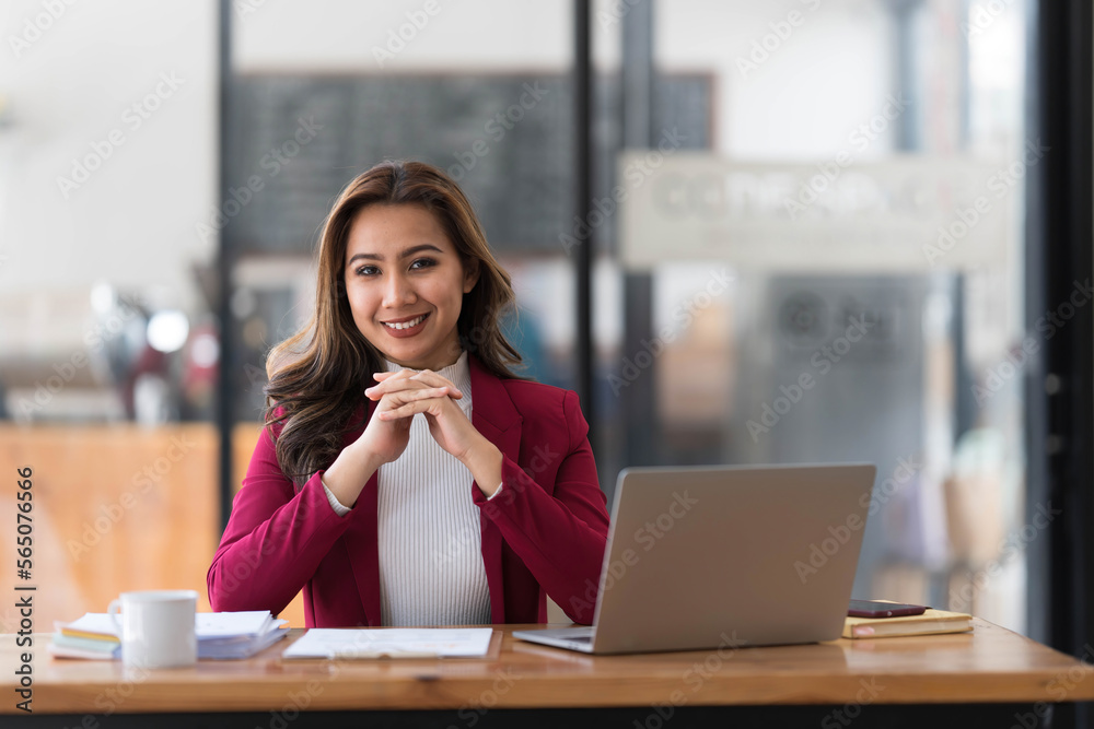 Attractive young asian woman using laptop computer while standing in a office. Attractive young asian woman using laptop computer while standing in a office.