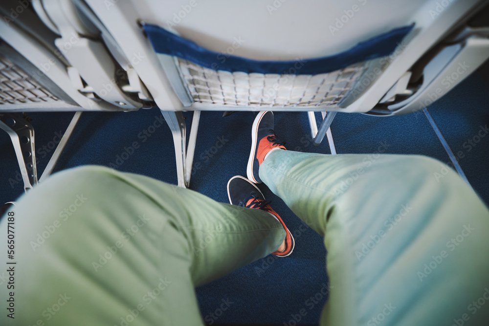 Personal perspective on legroom between seats in airplane. Man resting during flight. . - obrazy, fototapety, plakaty 