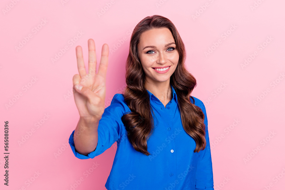 Photo of positive lovely lady wear blue clothes arm demonstrate three fingers isolated on pink color background Photo of positive lovely lady wear blue clothes arm demonstrate three fingers isolated on pink color background