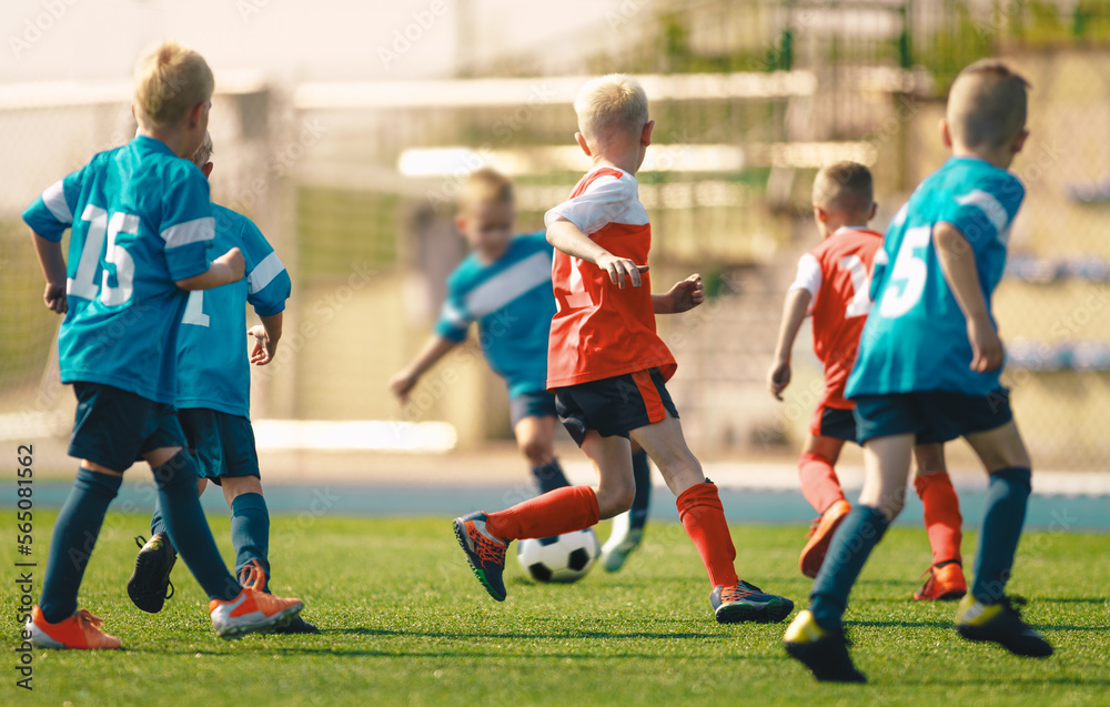 Fototapeta premium Football Soccer Game Between Kids. School Kids Play Football Match in Red and Blue Jersey Shirts