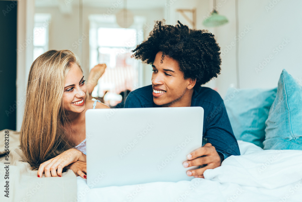 Young beautiful interracial couple relaxed lying down in bed on Young beautiful interracial couple relaxed lying down in bed on