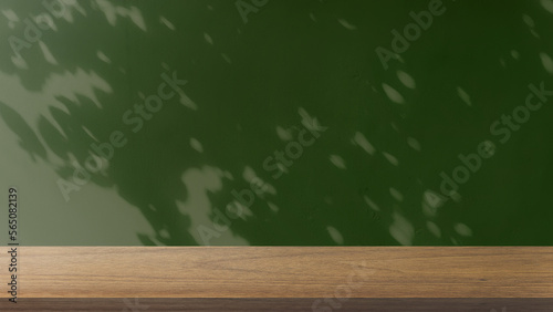 wood table in front of green concrete wall background with sunlight create leaves shadow on wall. panoramic banner mockup for advertising and product displayed. eco friendly interior concept.