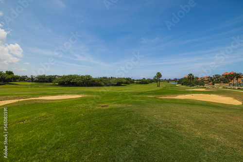 Gorgeous view of green grass golf field on background blue sky. Aruba. 