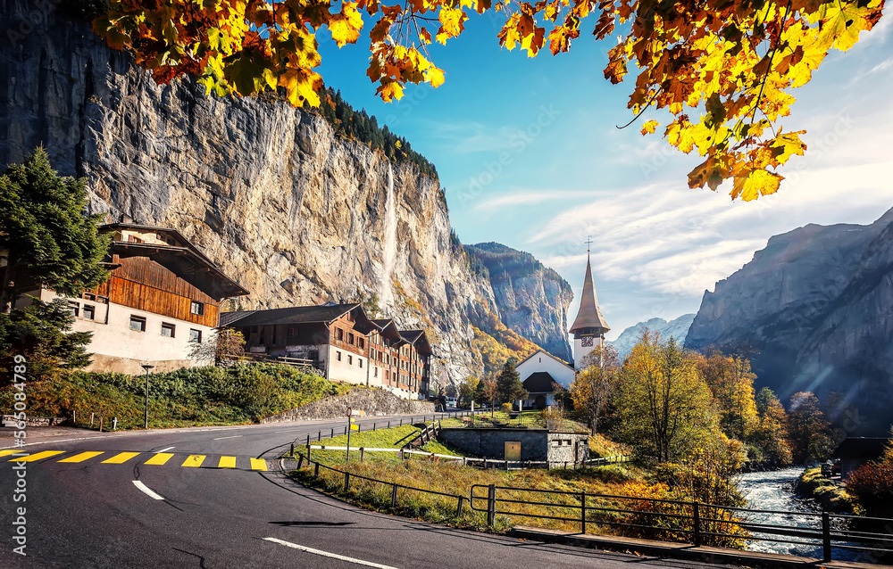 Naklejka premium Picturesque autumn landscape. Panoramic view of stunning mountain scenery in the Alps with fresh green meadows with fog in mountains on a sunny morning in autumn. Lauterbrunnen, Switzerland.