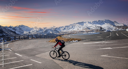 Amazing Nature Scenery at sunset. Mountain biking man on track Grossglockner High Alpine Road. Austria. Travel Lifestyle adventure concept. Outdoor wilderness vacations. Active recreation concept