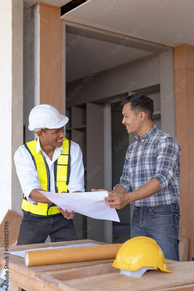 Two Asian male engineers are inspecting a job site and looking at drawings, consulting and debugging works to achieve quality work. Two Asian male engineers are inspecting a job site and looking at drawings, consulting and debugging works to achieve quality work.