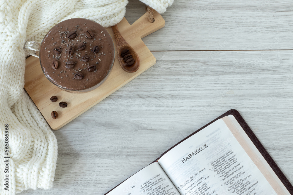 Habakkuk open holy bible book with coffee cup and cozy woolen scarf. Top table view. Winter and autumn composition. Morning study, Christian Old Testament prophecy. Biblical concept.	