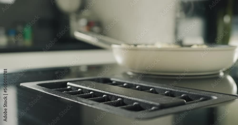 Potatoes are fried on a modern induction cooker. Built-in extractor works. Side view Potatoes are fried on a modern induction cooker. Built-in extractor works. Side view
