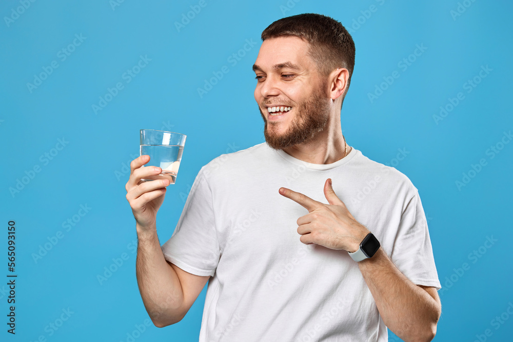 happy handsome man in white t-shirt showing drinking glass of water happy handsome man in white t-shirt showing drinking glass of water