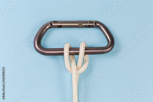 Rope clove hitch on a carabiner on a blue background photo