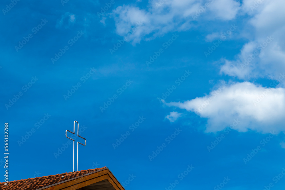 Crucifix on top tower of chapel in Brazil, with blue sky background Crucifix on top tower of chapel in Brazil, with blue sky background