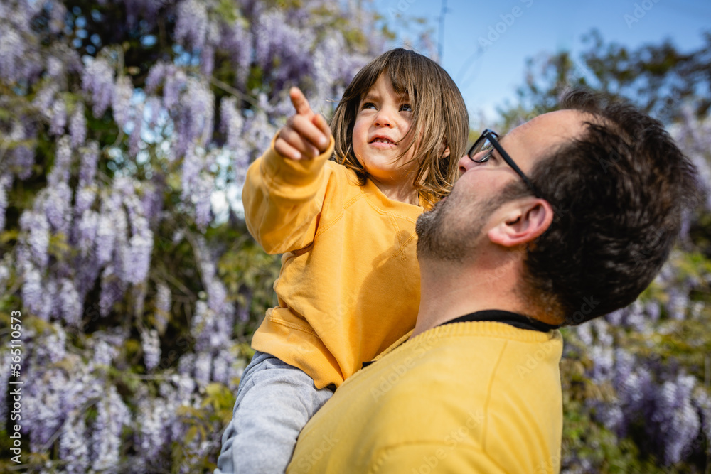 Wondering baby in yellow clothes asking a father outside Wondering baby in yellow clothes asking a father outside