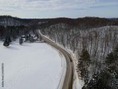 Rural highway winding through a snowy, white, winter forest landscape