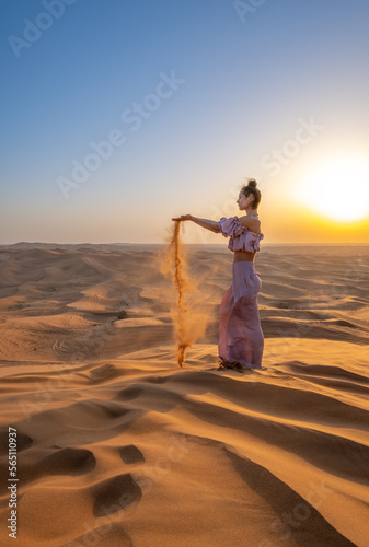 A woman dressed like a princess in a desert during sunset. Dubai  UAE.