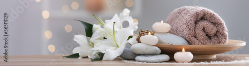 Candles, hot stones, towel and flowers on table in spa cabinet, closeup. Banner design with space for text
