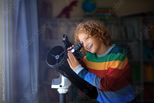 Little boy looking at stars through telescope