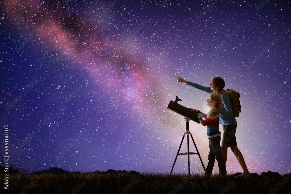 Man and child looking at stars through telescope