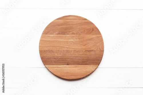 Empty round wooden cutting board on white table. Round cutting board or serving tray mockup. Flat lay, top view.