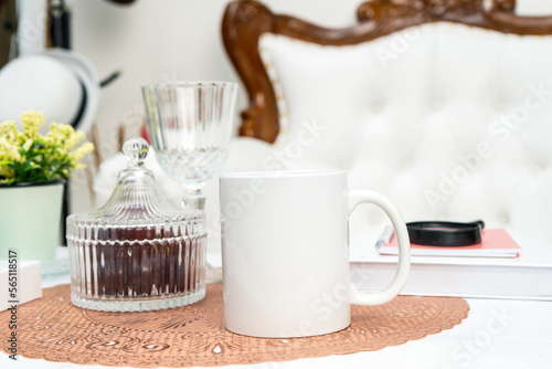 A white blank coffee mug standing out on a mat with some decorations placed around it