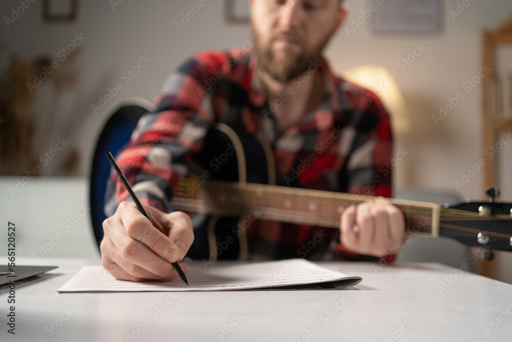 Φωτογραφία Man musician writing song with guitar at home, close up.