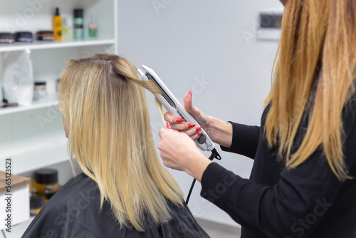 hairdresser doing stylish styling to woman in salon