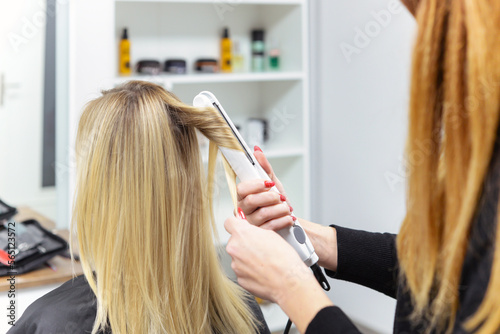 hairdresser doing stylish styling to woman in salon